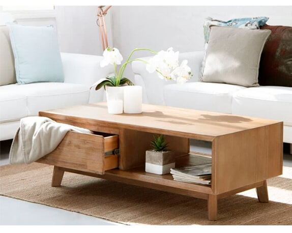 Acacia wood coffee table styled with a white orchid and books in living room setting